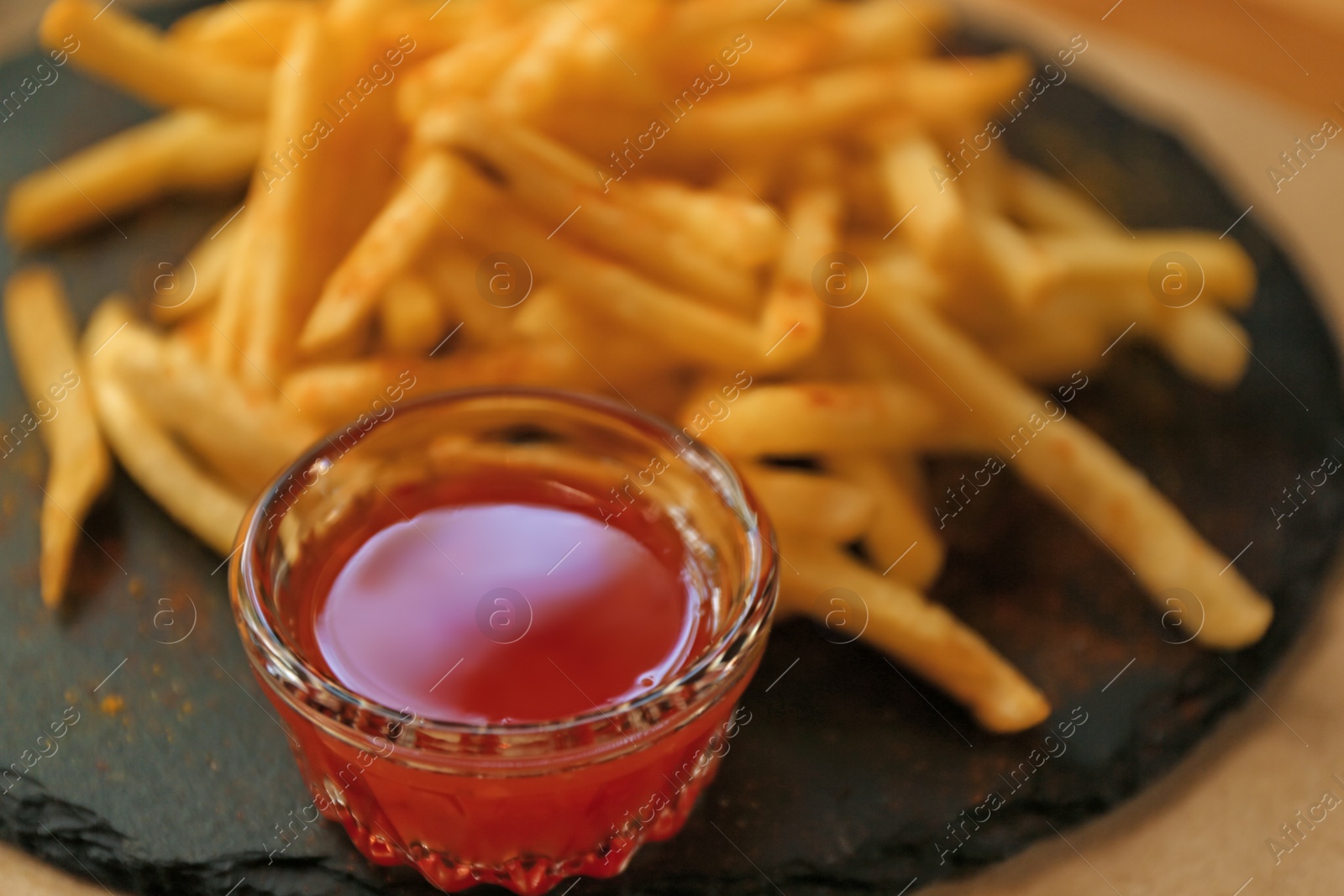 Delicious hot french fries with red sauce served on table, closeup Photo of Delicious hot french fries with red sauce served on table, closeup