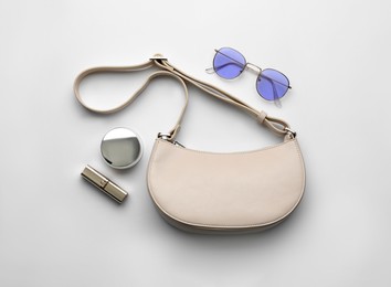 Flat lay composition with stylish woman's bag on light background Photo of Flat lay composition with stylish woman's bag on light background