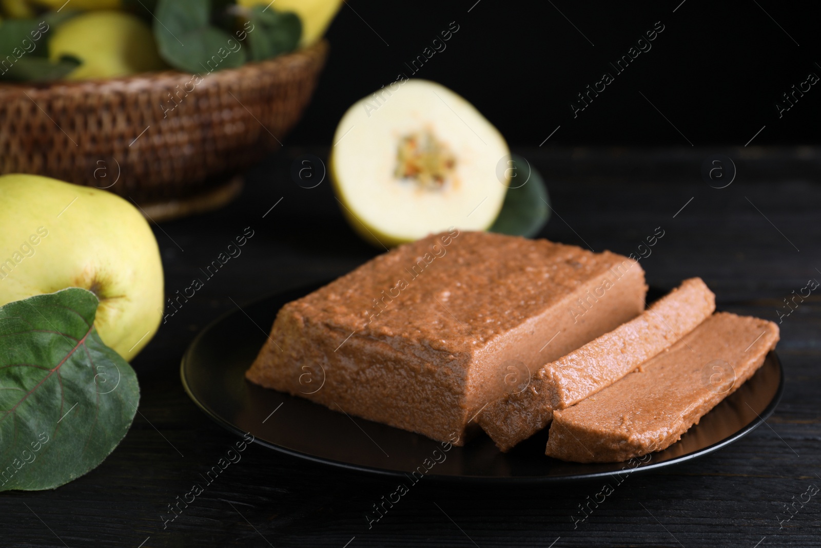 Black plate with quince paste on dark table, closeup Photo of Black plate with quince paste on dark table, closeup