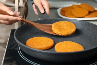 Woman cooking breaded cutlets in frying pan on stove, closeup Photo of Woman cooking breaded cutlets in frying pan on stove, closeup