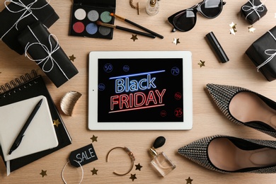 Flat lay composition with tablet, gifts and accessories on wooden background. Black Friday sale Photo of Flat lay composition with tablet, gifts and accessories on wooden background. Black Friday sale