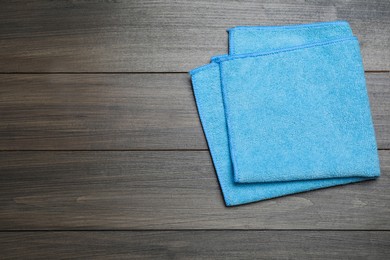 Light blue microfiber cloth on wooden table, top view. Space for text Photo of Light blue microfiber cloth on wooden table, top view. Space for text