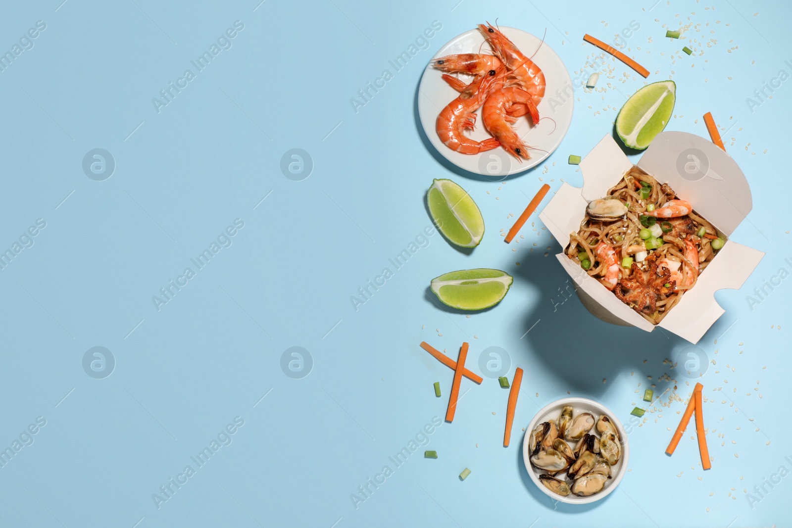 Flat lay composition with noodle wok and ingredients on light blue background. Space for text Photo of Flat lay composition with noodle wok and ingredients on light blue background. Space for text