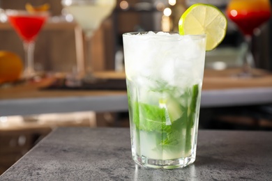 Photo of Mojito cocktail on grey table in bar. Space for text