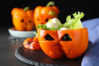 Bell pepper with black olives, mozzarella and lettuce as Halloween monster on dark table, closeup Photo of Bell pepper with black olives, mozzarella and lettuce as Halloween monster on dark table, closeup