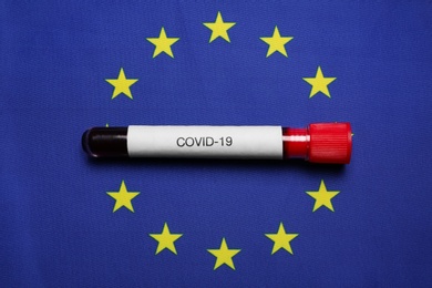 Test tube with blood sample on European Union flag background, top view. Coronavirus outbreak Photo of Test tube with blood sample on European Union flag background, top view. Coronavirus outbreak