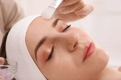 Young woman during face peeling procedure in salon, closeup Photo of Young woman during face peeling procedure in salon, closeup