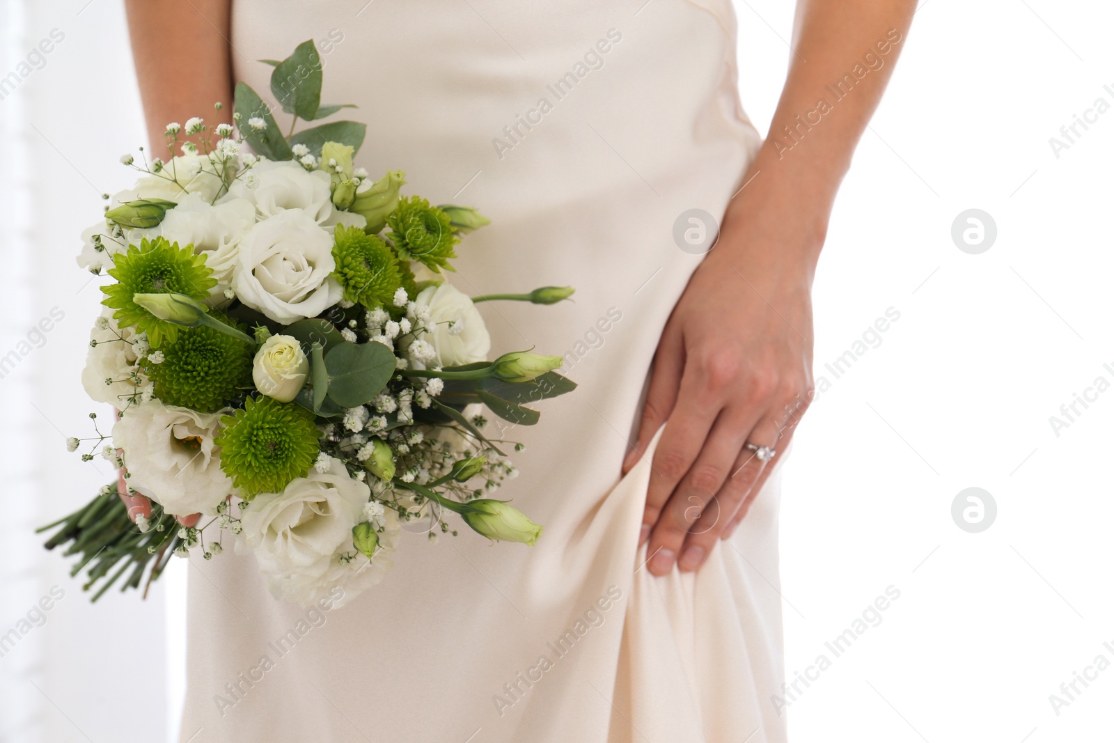 Photo of Bride holding beautiful bouquet with Eustoma flowers indoors, closeup