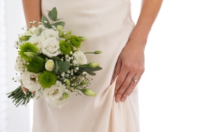 Bride holding beautiful bouquet with Eustoma flowers indoors, closeup Photo of Bride holding beautiful bouquet with Eustoma flowers indoors, closeup