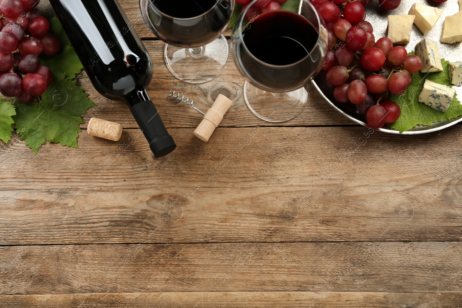 Tasty red wine and snacks on wooden table, flat lay. Space for text Photo of Tasty red wine and snacks on wooden table, flat lay. Space for text