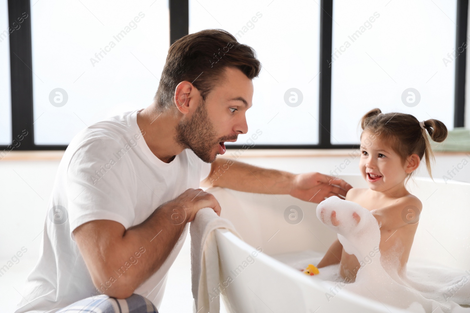 Young father with cute little daughter in bathroom Photo of Young father with cute little daughter in bathroom