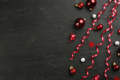 Shiny serpentine streamers and Christmas balls on black background, flat lay. Space for text Photo of Shiny serpentine streamers and Christmas balls on black background, flat lay. Space for text