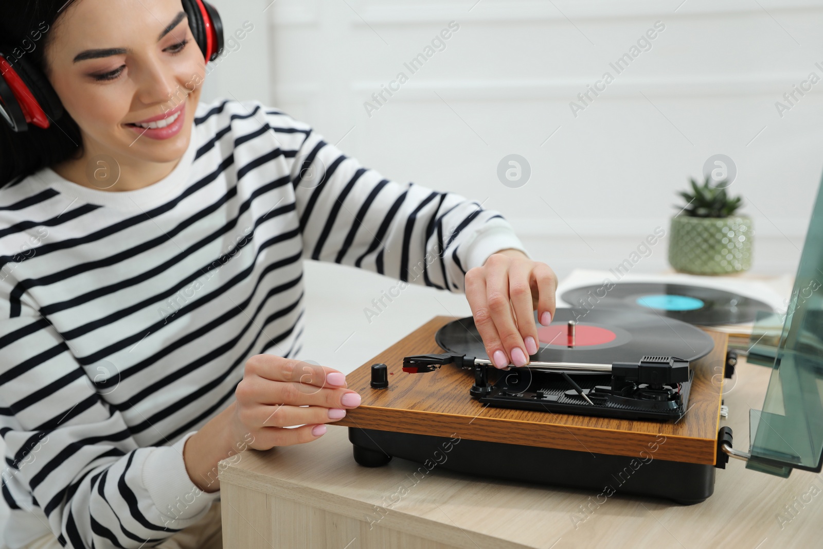 Woman listening to music with turntable at home Photo of Woman listening to music with turntable at home