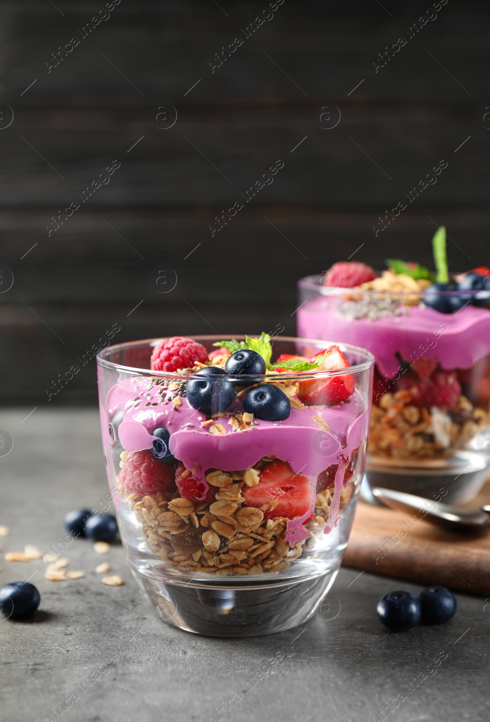 Tasty dessert with acai smoothie, granola and berries on grey table Image of Tasty dessert with acai smoothie, granola and berries on grey table