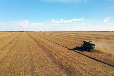 Modern combine harvester working in field on sunny day. Agriculture industry Photo of Modern combine harvester working in field on sunny day. Agriculture industry