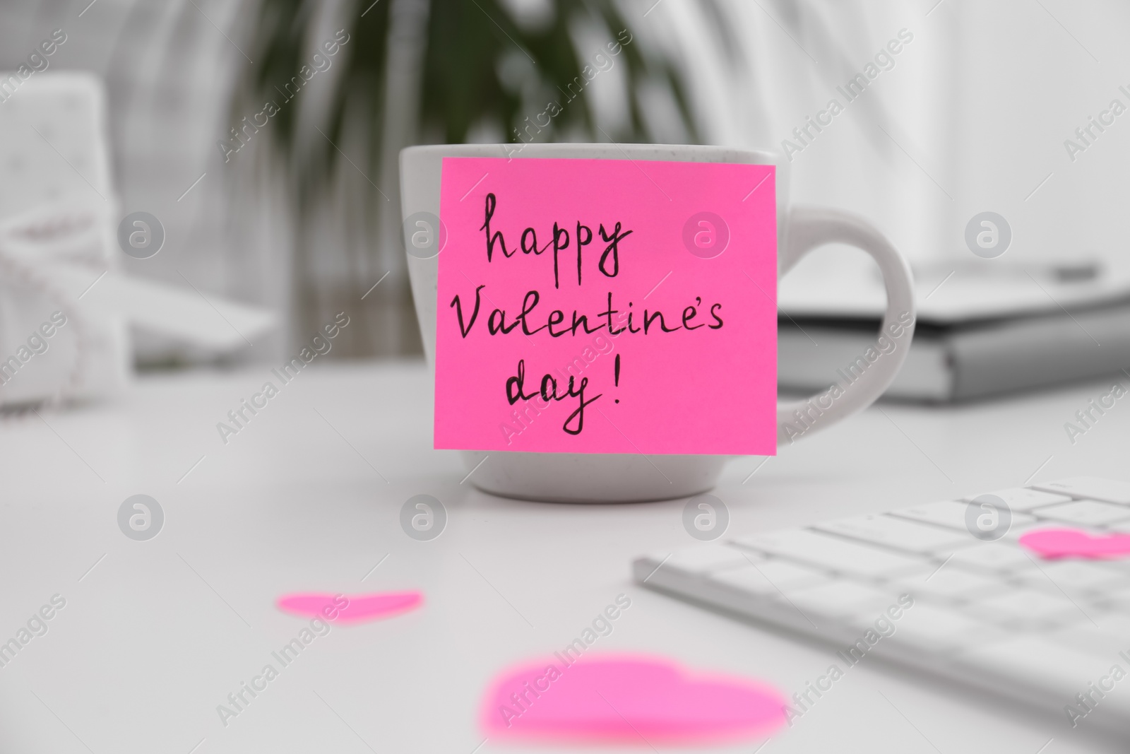 Memory sticker with phrase Happy Valentine's Day on cup at workplace Photo of Memory sticker with phrase Happy Valentine's Day on cup at workplace