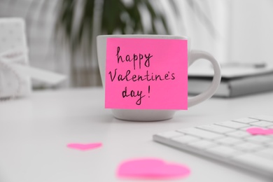 Memory sticker with phrase Happy Valentine's Day on cup at workplace Photo of Memory sticker with phrase Happy Valentine's Day on cup at workplace