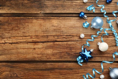 Blue serpentine streamers and Christmas baubles on wooden background, flat lay. Space for text Photo of Blue serpentine streamers and Christmas baubles on wooden background, flat lay. Space for text