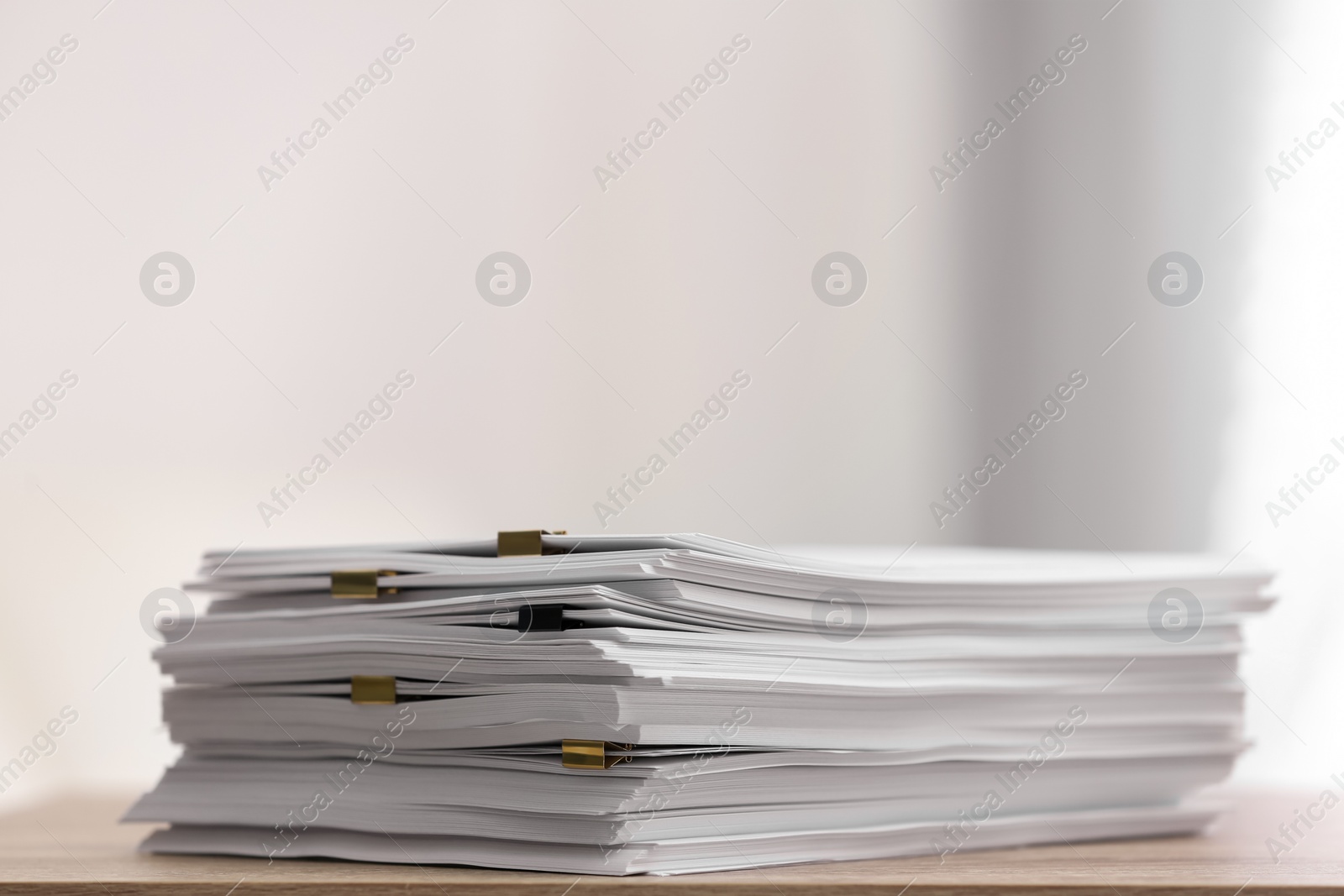 Stack of blank paper with binder clips on wooden table. Space for text Photo of Stack of blank paper with binder clips on wooden table. Space for text