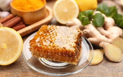 Fresh honeycomb and other products on wooden table, closeup. Natural antibiotics Photo of Fresh honeycomb and other products on wooden table, closeup. Natural antibiotics