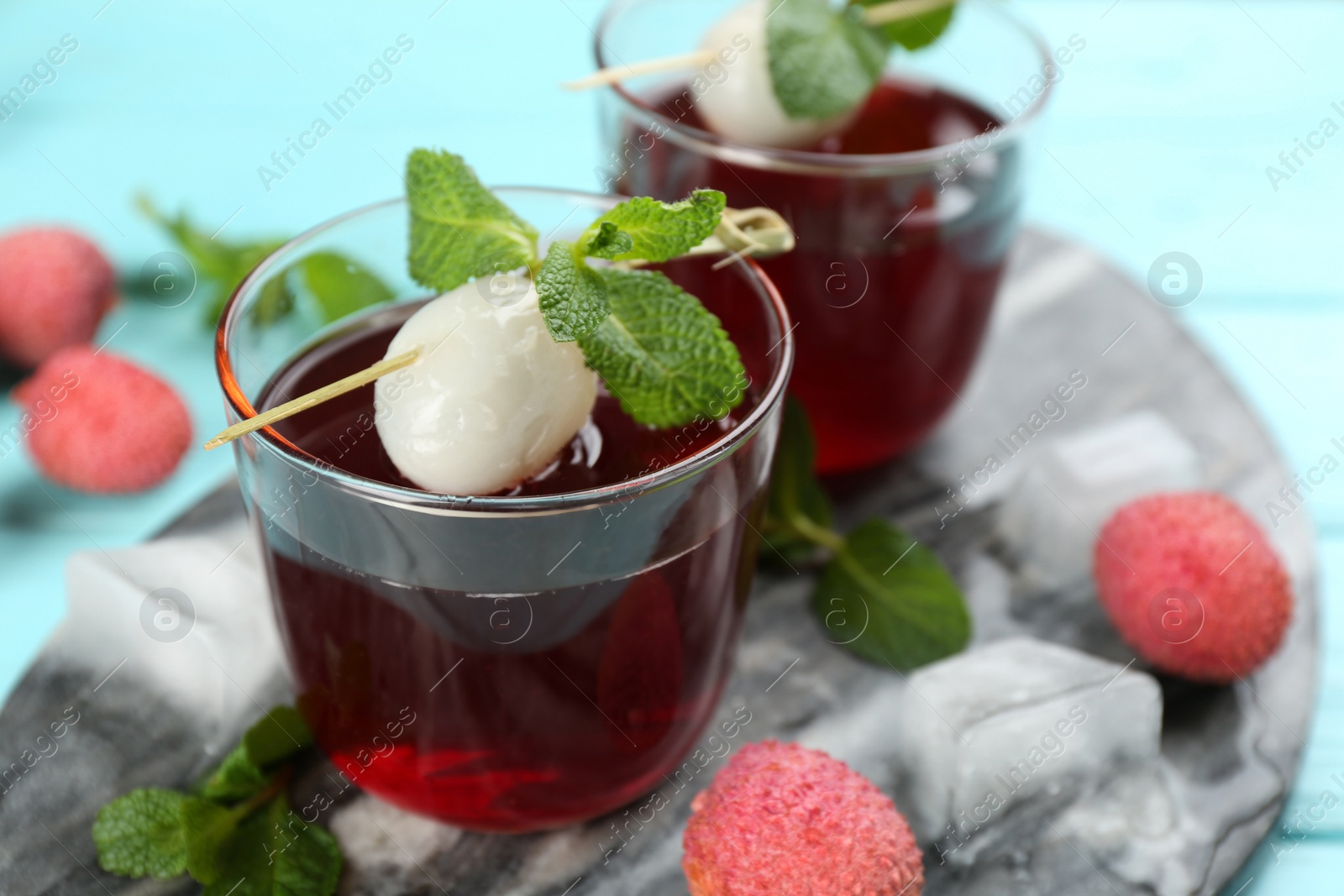 Lychee cocktail on cyan table, closeup. Space for text Photo of Lychee cocktail on cyan table, closeup. Space for text