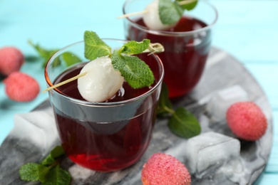 Lychee cocktail on cyan table, closeup. Space for text Photo of Lychee cocktail on cyan table, closeup. Space for text