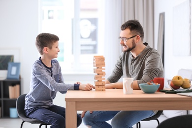 Little boy and his dad playing board game together at home Photo of Little boy and his dad playing board game together at home