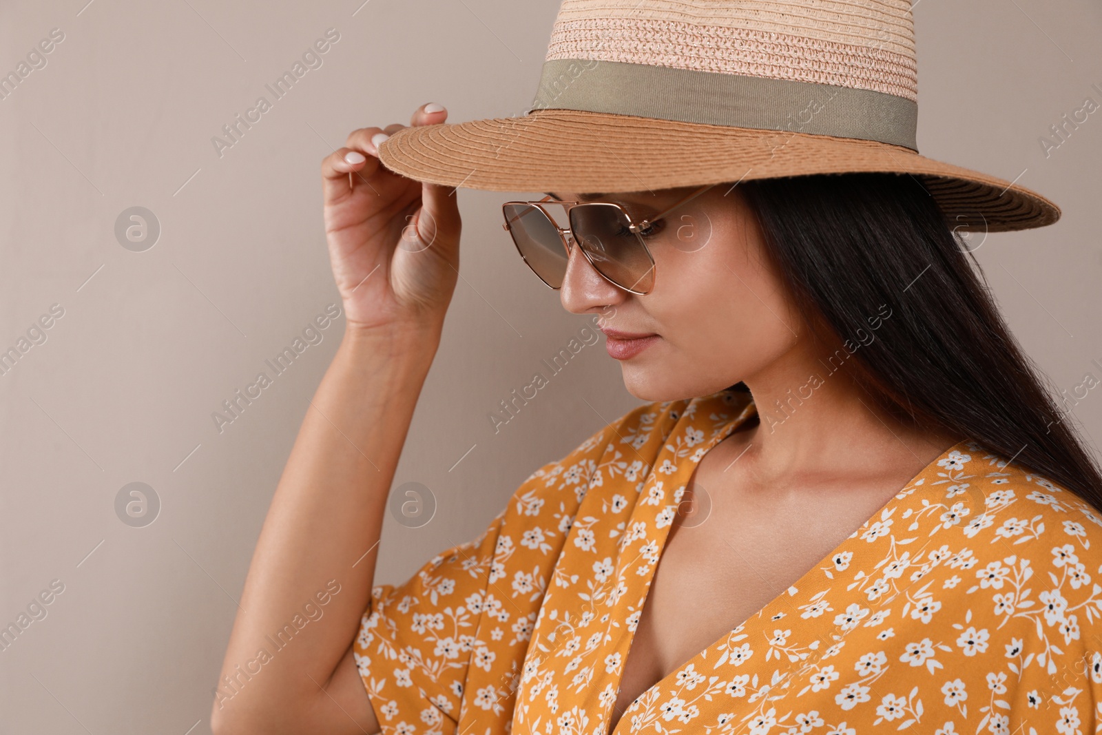 Beautiful young woman with straw hat and stylish sunglasses on beige background Photo of Beautiful young woman with straw hat and stylish sunglasses on beige background