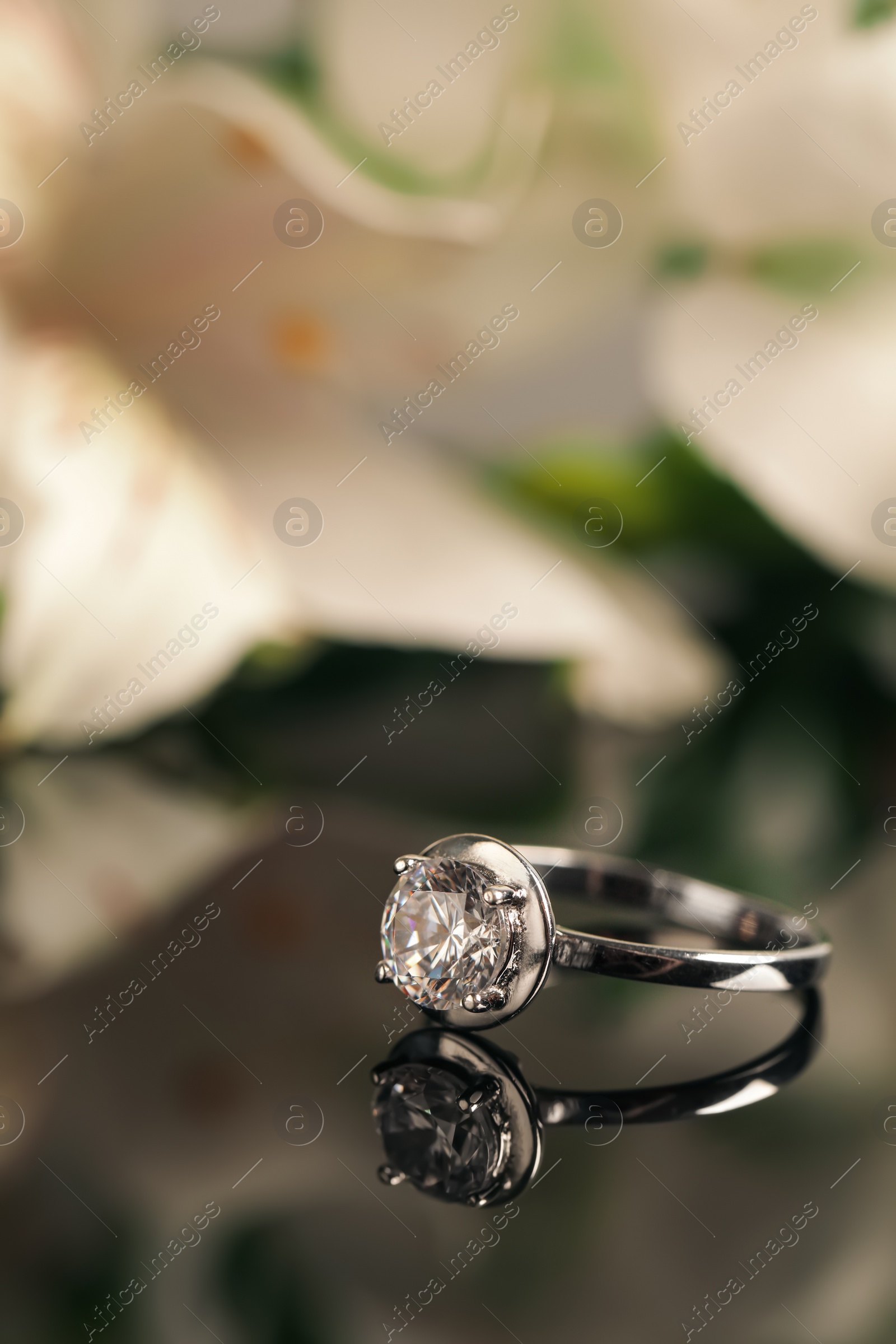 Beautiful engagement ring against blurred background, space for text Photo of Beautiful engagement ring against blurred background, space for text