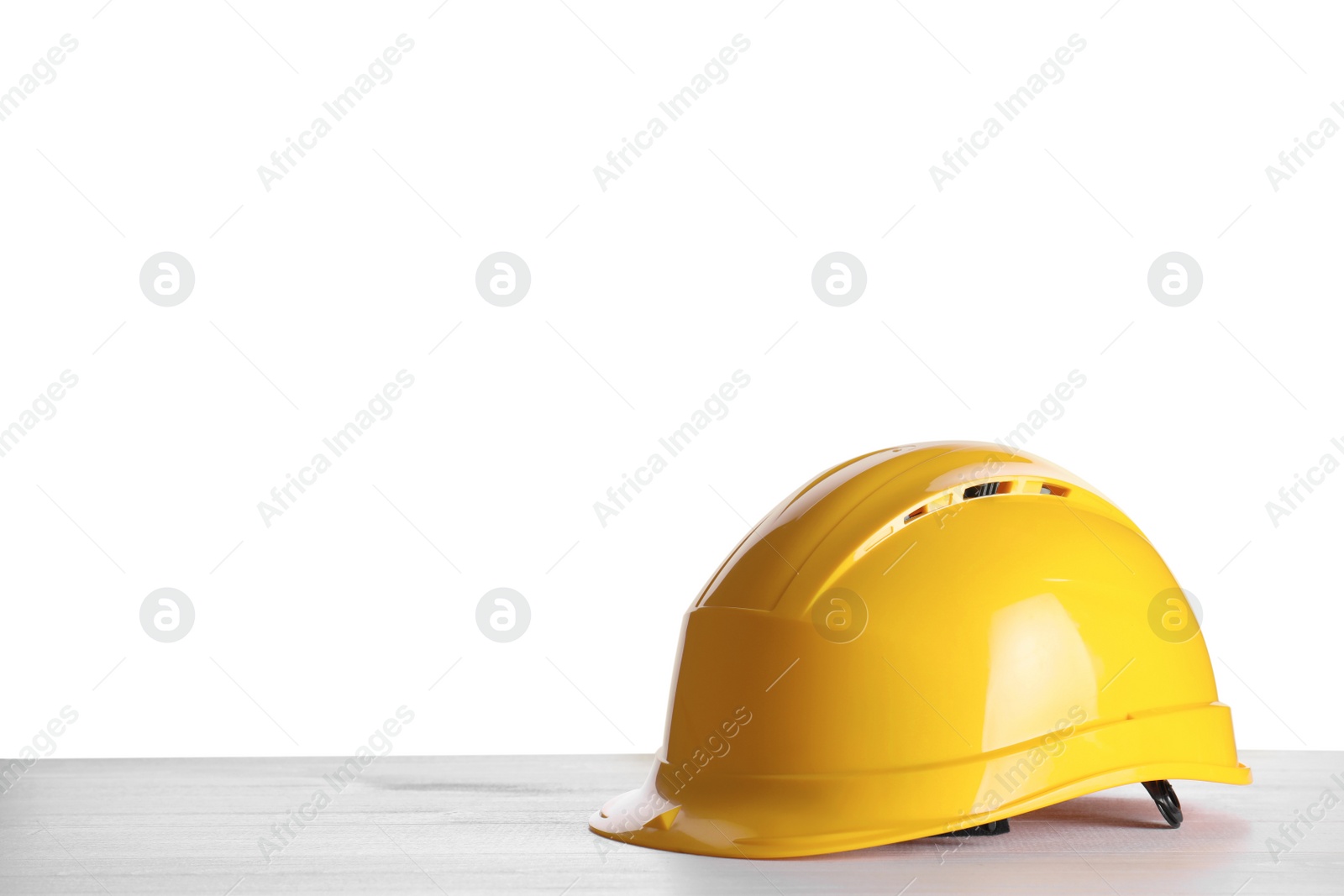 Yellow hard hat on wooden table against white background. Space for text Photo of Yellow hard hat on wooden table against white background. Space for text
