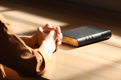 Religious woman praying over Bible indoors, closeup Photo of Religious woman praying over Bible indoors, closeup