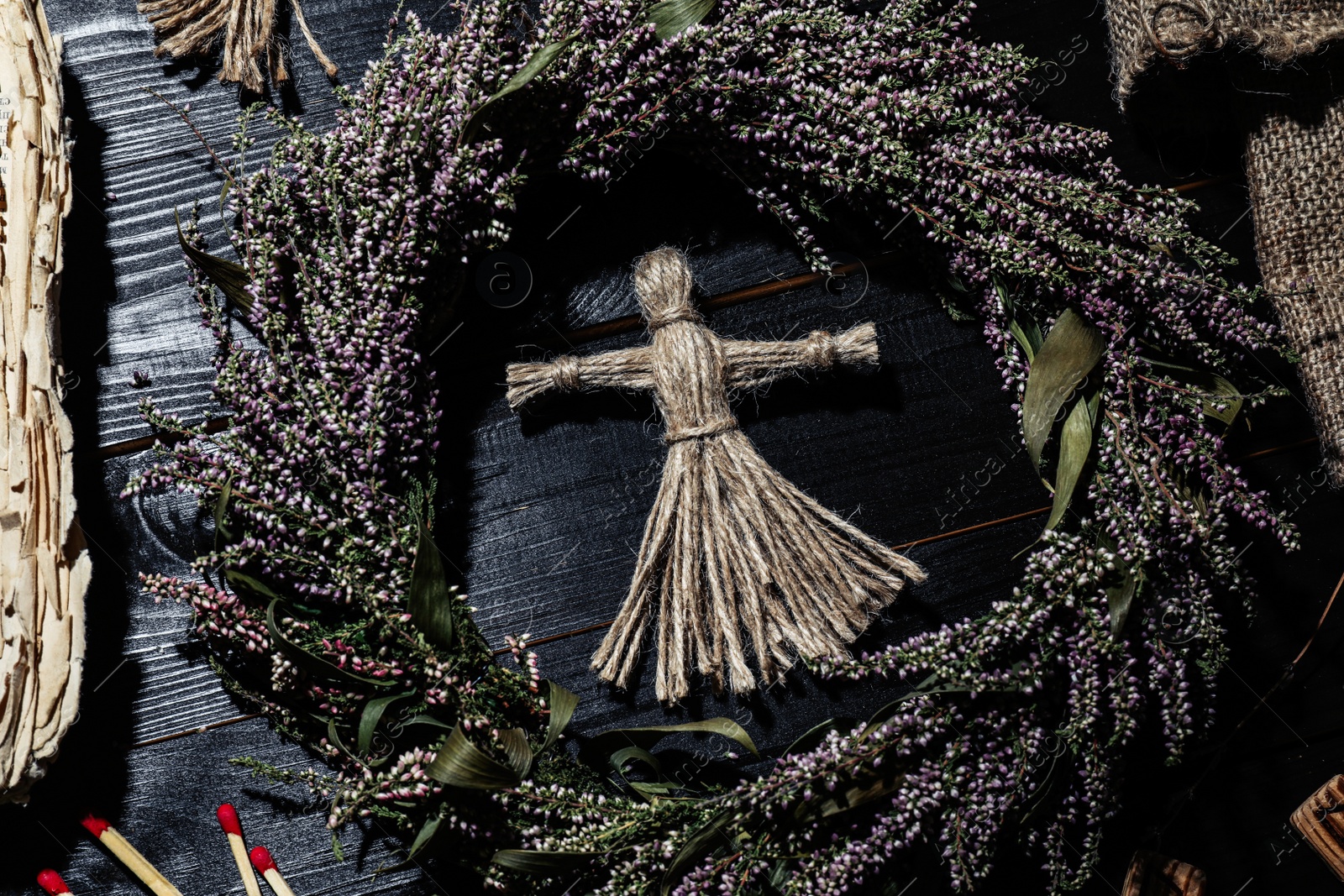 Female voodoo doll surrounded by ceremonial items on black wooden background, flat lay Photo of Female voodoo doll surrounded by ceremonial items on black wooden background, flat lay