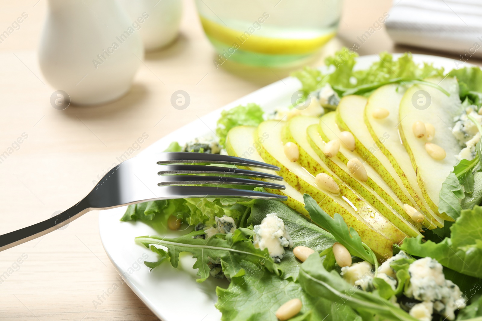 Fresh salad with pear served on wooden table Photo of Fresh salad with pear served on wooden table