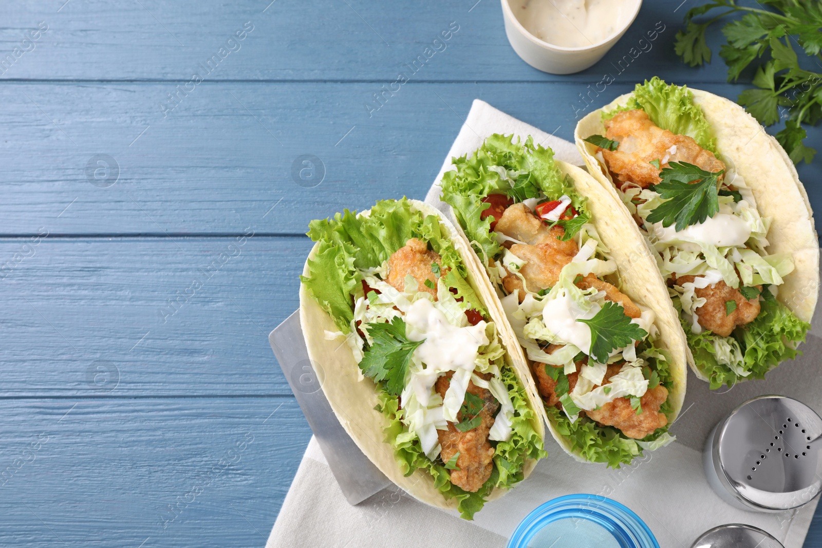 Yummy fish tacos served on blue wooden table, flat lay. Space for text Photo of Yummy fish tacos served on blue wooden table, flat lay. Space for text