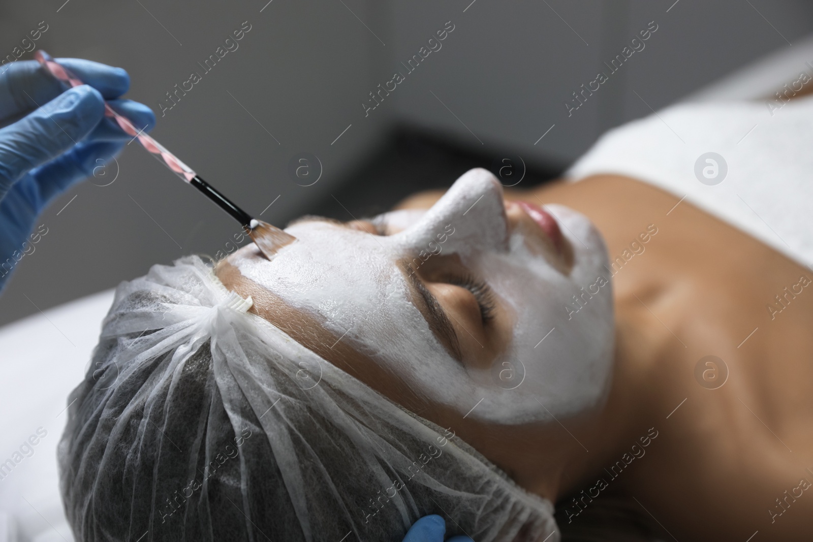 Cosmetologist applying mask on client's face in spa salon Photo of Cosmetologist applying mask on client's face in spa salon