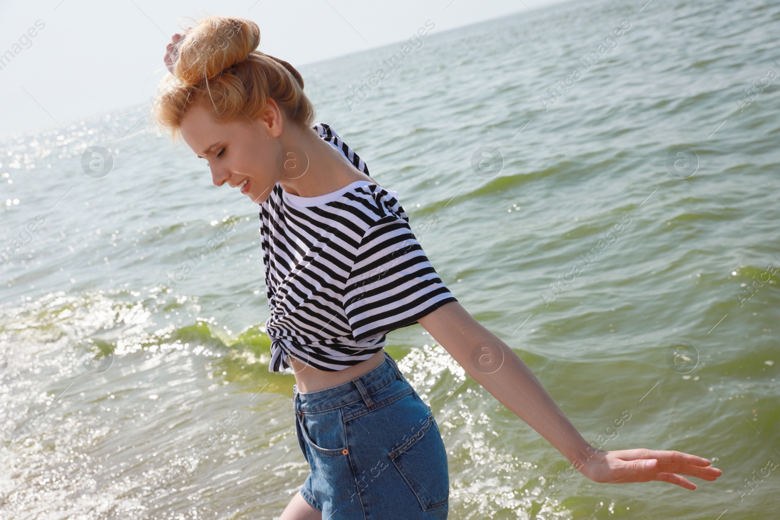 Beautiful young woman near sea on sunny day in summer Photo of Beautiful young woman near sea on sunny day in summer