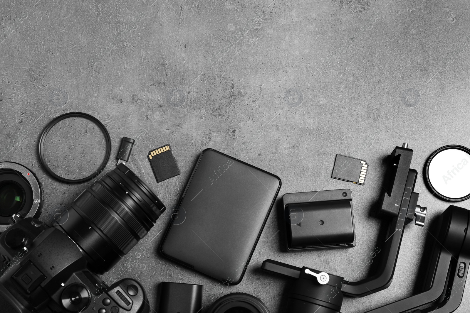 Camera and video production equipment on grey stone background, flat lay. Space for text Photo of Camera and video production equipment on grey stone background, flat lay. Space for text