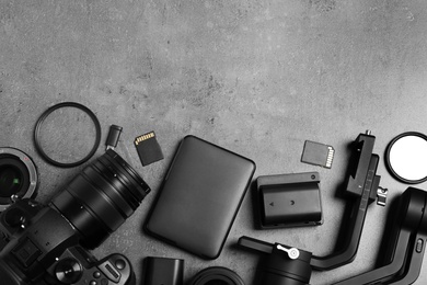 Camera and video production equipment on grey stone background, flat lay. Space for text Photo of Camera and video production equipment on grey stone background, flat lay. Space for text