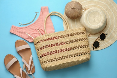 Flat lay composition with woman's straw bag on light blue background Photo of Flat lay composition with woman's straw bag on light blue background