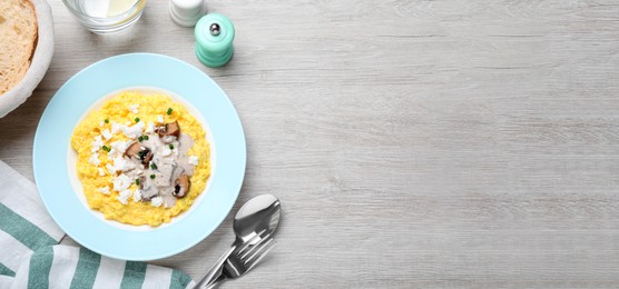 Traditional Ukrainian banosh served with brynza and mushrooms on light wooden table, flat lay. Space for text Photo of Traditional Ukrainian banosh served with brynza and mushrooms on light wooden table, flat lay. Space for text