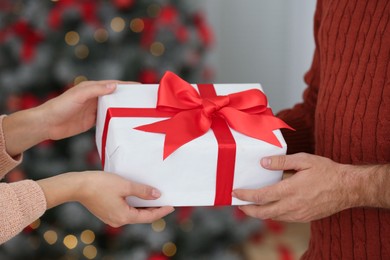 Couple with Christmas gift at home, closeup Image of Couple with Christmas gift at home, closeup