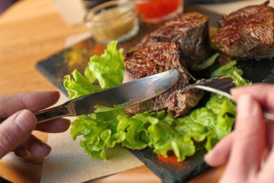 Woman eating tasty shish kebab in cafe Photo of Woman eating tasty shish kebab in cafe