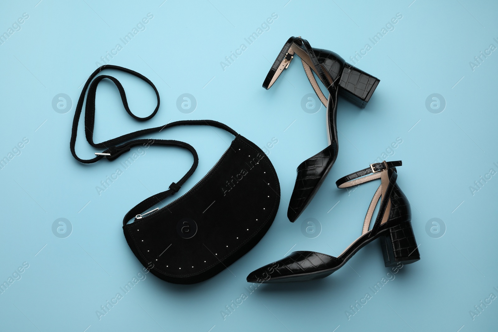 Stylish woman's bag and shoes on light blue background, flat lay Photo of Stylish woman's bag and shoes on light blue background, flat lay