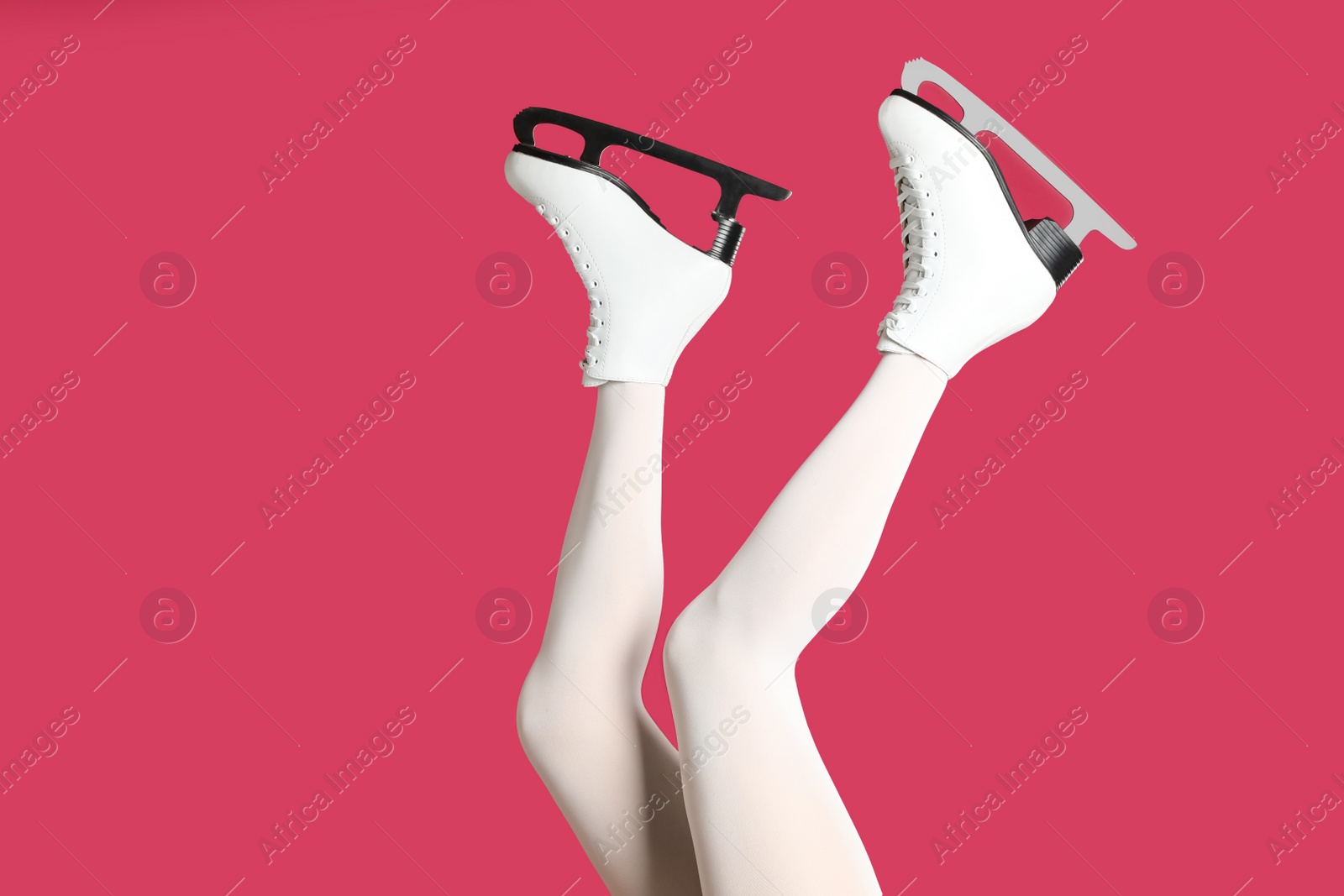 Woman in elegant white ice skates on pink background, closeup of legs Photo of Woman in elegant white ice skates on pink background, closeup of legs