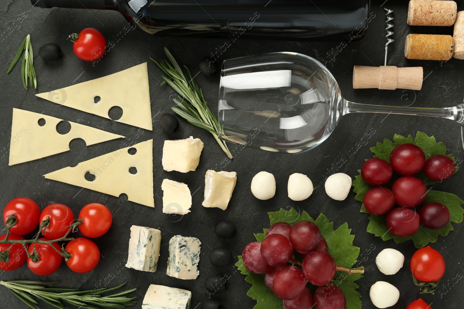 Tasty red wine and snacks on black table, flat lay Photo of Tasty red wine and snacks on black table, flat lay
