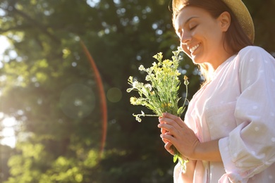 Young woman with beautiful bouquet outdoors on sunny day, space for text Photo of Young woman with beautiful bouquet outdoors on sunny day, space for text