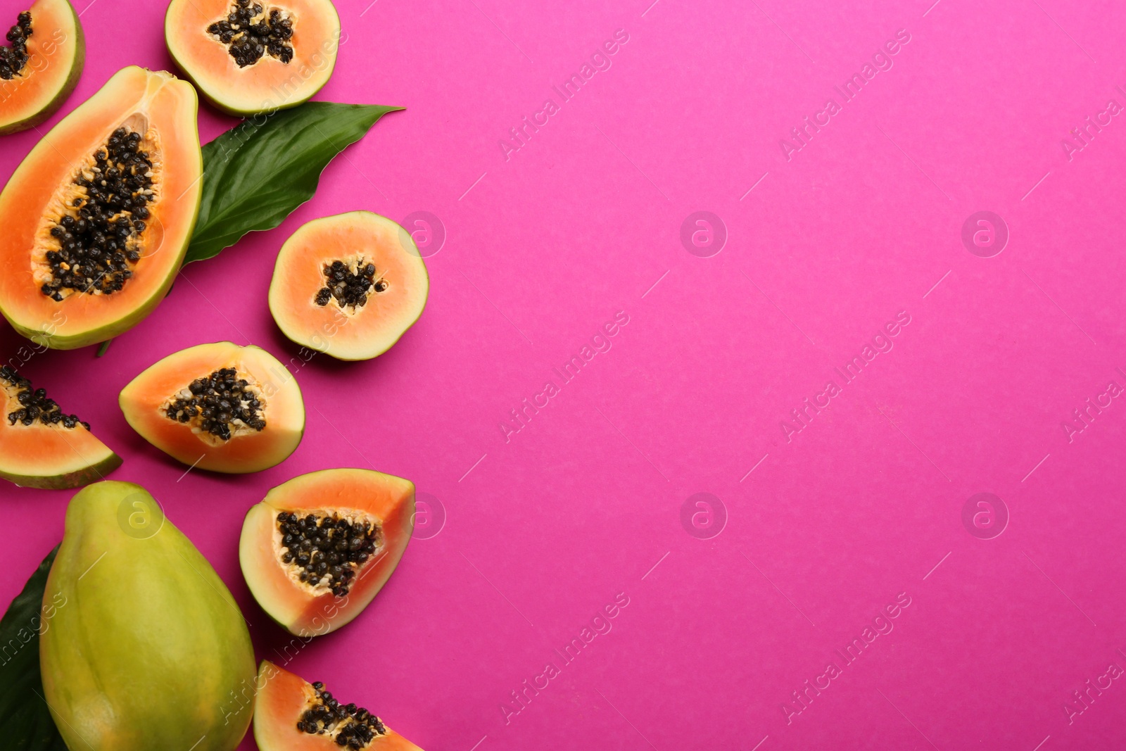 Photo of Fresh ripe papaya fruits with green leaves on purple background, flat lay. Space for text