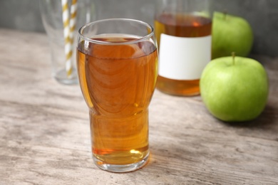 Glass of fresh apple juice on wooden table Photo of Glass of fresh apple juice on wooden table