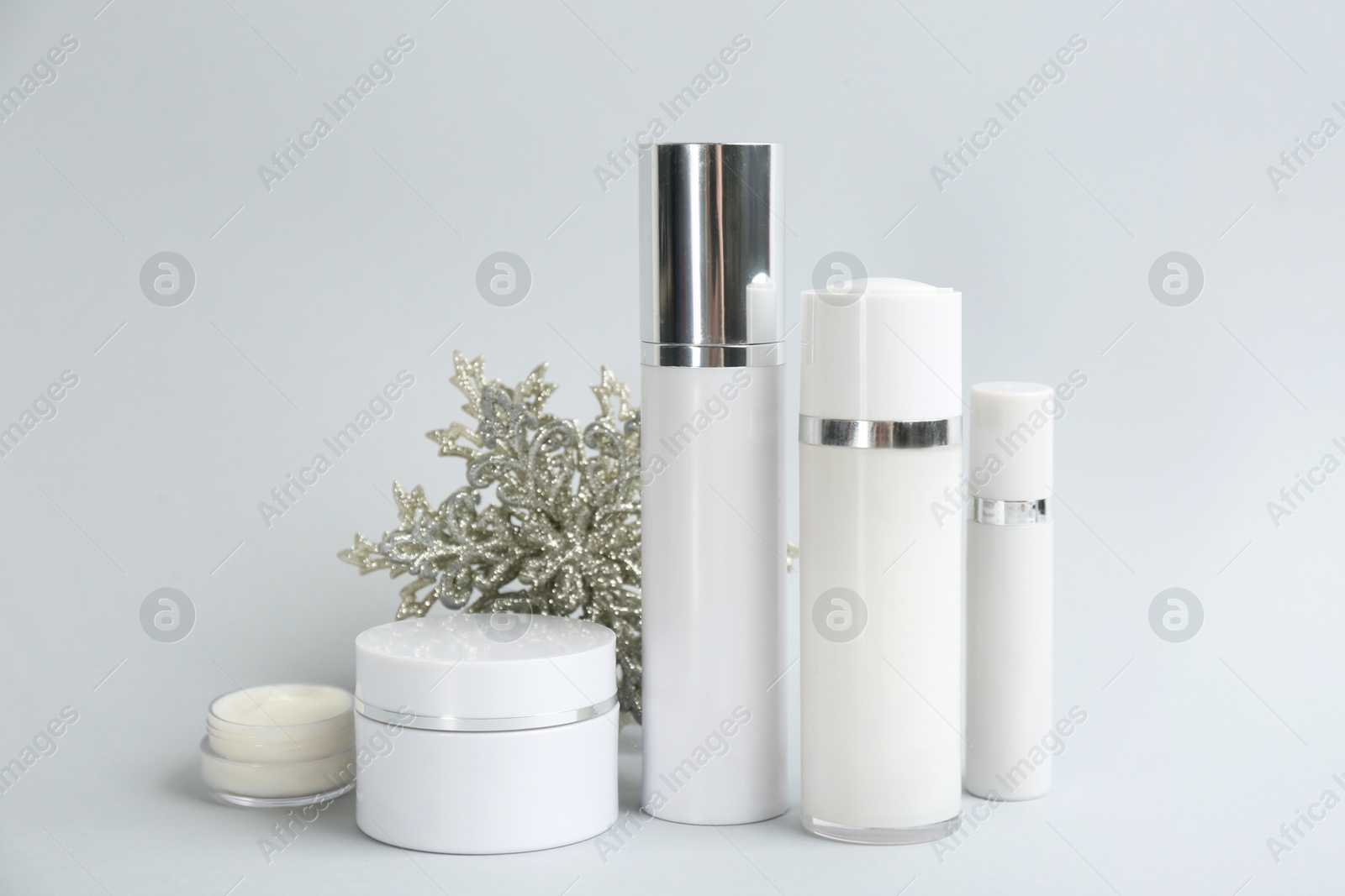 Beautiful composition with cosmetic products on light grey background. Winter care Photo of Beautiful composition with cosmetic products on light grey background. Winter care