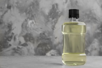 Mouthwash on grey table, space for text Photo of Mouthwash on grey table, space for text